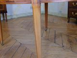 a wooden table that is on wheels in the middle of a room