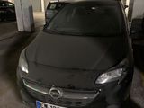 une voiture noire garée dans un parking à étages, à côté d'autres voitures