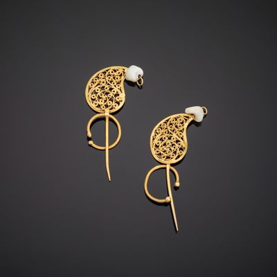 a pair of gold earrings with pearls on them