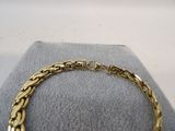 a close up of a gold bracelet on a display case