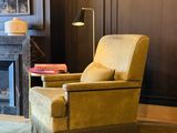 a yellow chair sitting in front of a fireplace in a living room