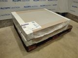 un carton contenant un matelas, posé sur une palette devant un mur