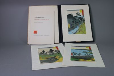 three books on a table with a picture of a river in the background