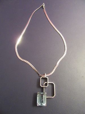Gros plan sur un collier orné d'une pierre verte