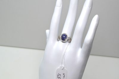une main sur laquelle est passée une bague à laquelle est attachée une étiquette