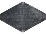 une vieille enseigne noire portant l'inscription « Lima » sur la façade d'un immeuble
