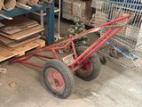 un chariot rouge muni d'une poignée rouge, posé dans un entrepôt