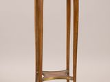 une petite table en bois avec un plateau rond et un piètement en bois