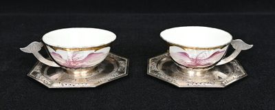 une paire de tasses et soucoupes plaquées argent, ornées de fleurs roses