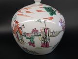 a white vase with a painting on it on a table