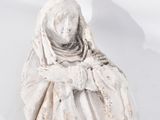 une vieille statue représentant une femme assise sur une surface blanche