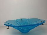 blue glass bowl on stand on a white surface