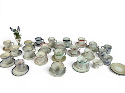 il y a toutes sortes de tasses et de soucoupes sur la table