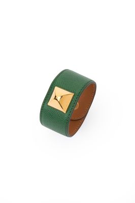 un bracelet en cuir vert orné d'une pyramide dorée