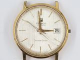 a close up of a gold watch on a white surface