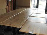 des tables et des tabourets dans une pièce où est accrochée une affiche au mur