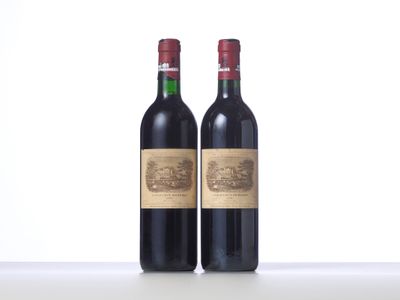 two bottles of red wine sitting next to each other on a table
