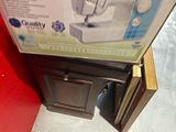 a box with a sewing machine in it sitting on the floor