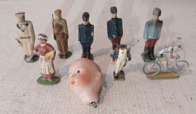 de nombreuses figurines représentant des personnes et un cochon, posées par terre