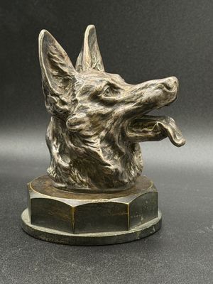 an image of a bronze dog statue on a black surface