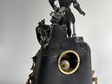 statue of a man on a clock with a dog on top of it
