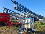a blue crane sitting on top of a field next to a red truck