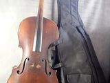 a violin sitting next to a guitar case on a couch