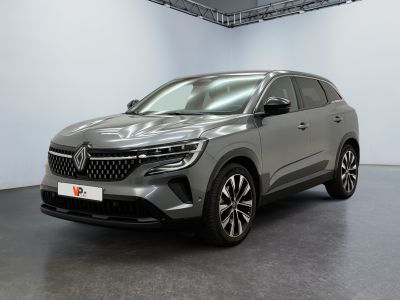 Une voiture grise est garée dans une grande pièce.