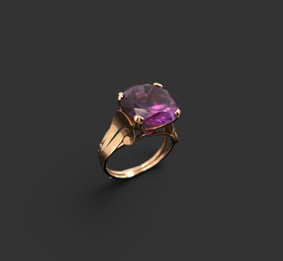 une bague en or sertie d'une pierre d'améthorate au centre