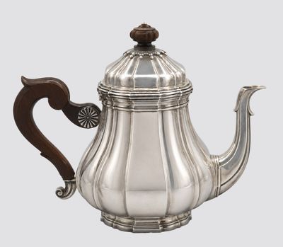 an antique silver teapot with a wooden handle on a white background