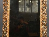 an ornate gold framed mirror with a man taking a picture