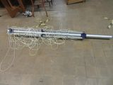 a metal pole with wires on the floor in a room