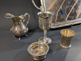 a silver plate and silver cups on a table