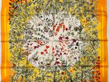 an orange and yellow square scarf with a floral design