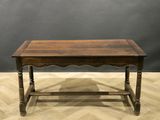an old wooden table on a wooden floor with a gray wall in the background