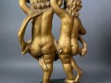 an image of a gold statue of two cherenshes on a marble base