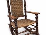 un vieux fauteuil à bascule en bois avec une assise tressée sur fond blanc
