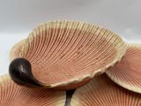 three seashells on a plate with a bird on top of them