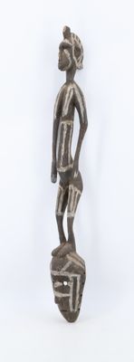 statue d'un homme debout au sommet d'un rocher, sur un fond blanc