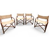 three wooden chairs with tan slingers on a white background