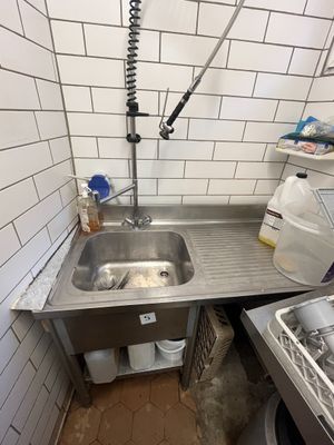 un évier situé dans un coin de la cuisine, équipé d'un robinet
