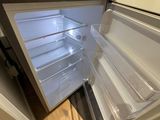 a small refrigerator with its door open on the floor
