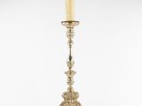 a silver candle holder with a green candle on top of it