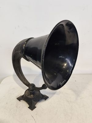 une vieille corne noire posée sur une surface blanche, avec un fond blanc