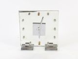 a white clock that is sitting on top of a table