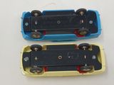 two toy cars sitting side by side on a white surface