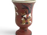 a red vase with a painting of birds on it