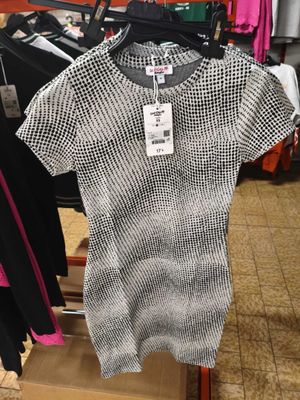 une chemise noire et blanche suspendue à un portant dans un magasin