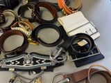 a pile of assorted belts and bracelets on a table
