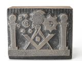 une image représentant une plaque métallique sur laquelle figure un symbole maçonnique